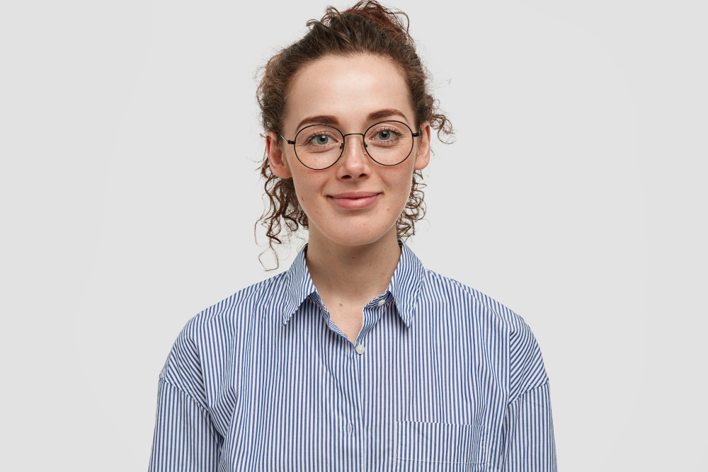 indoor-portrait-beautiful-freckled-woman-with-dark-curly-hair-wears-fashionable-striped-shirt-rejoices-day-off-isolated-white-wall-curly-satisfied-woman-stands-indoor-alone